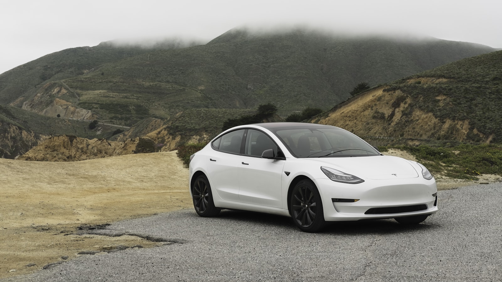 An electric car driving along an open road on a clear day.