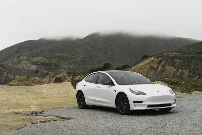 An electric car driving along an open road on a clear day.