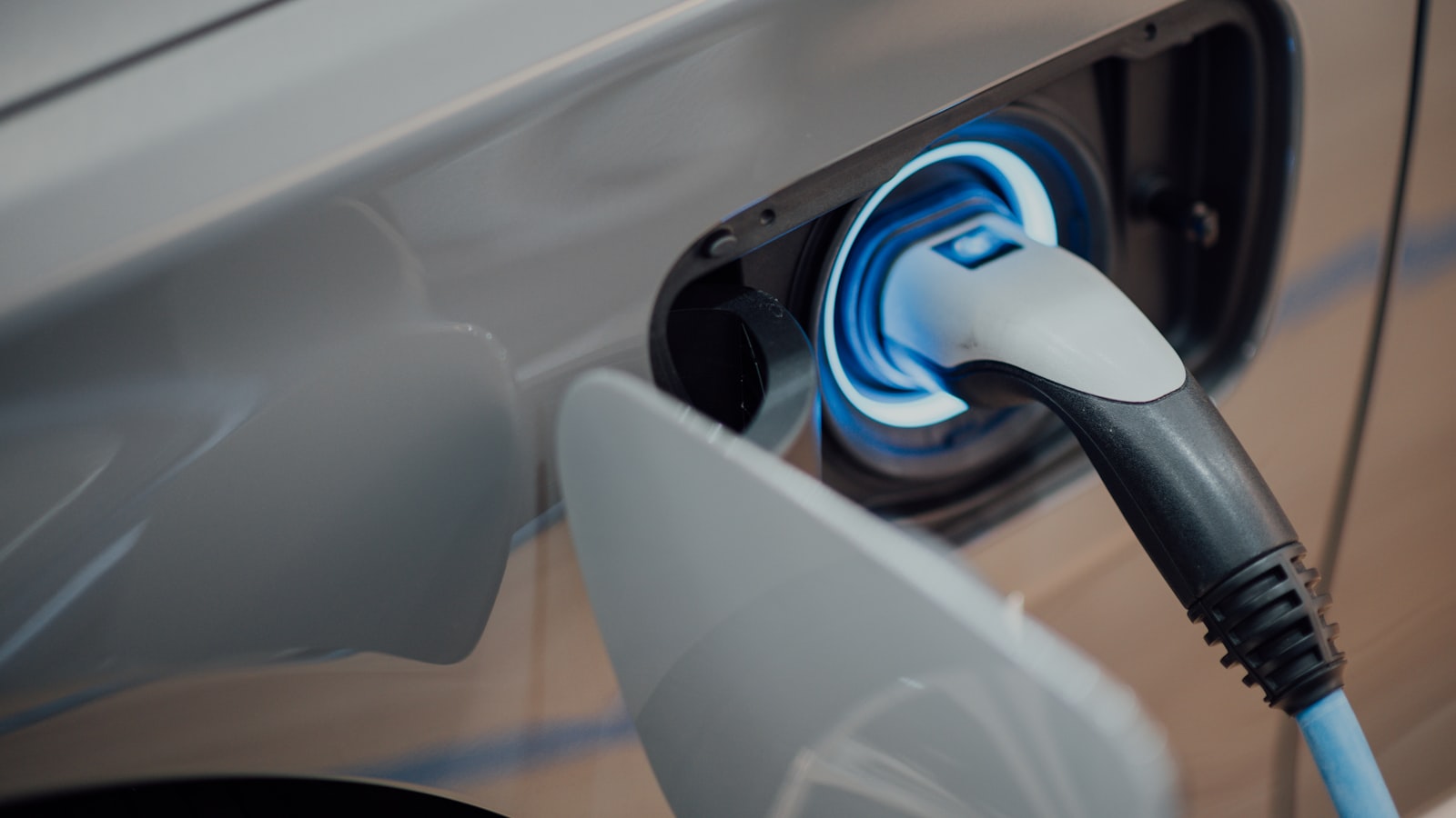 An electric car parked and plugged into a public charging station.