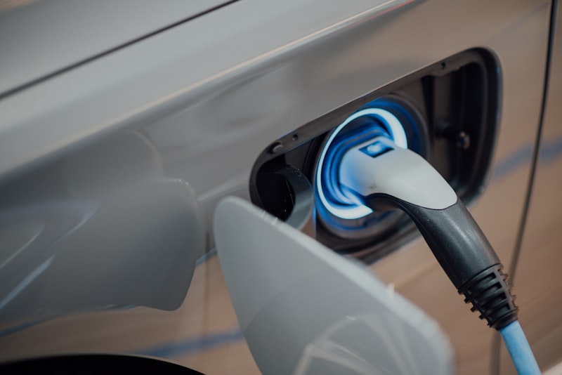 An electric car parked and plugged into a public charging station.