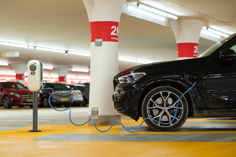 An electric car plugged in to charge on a home driveway.